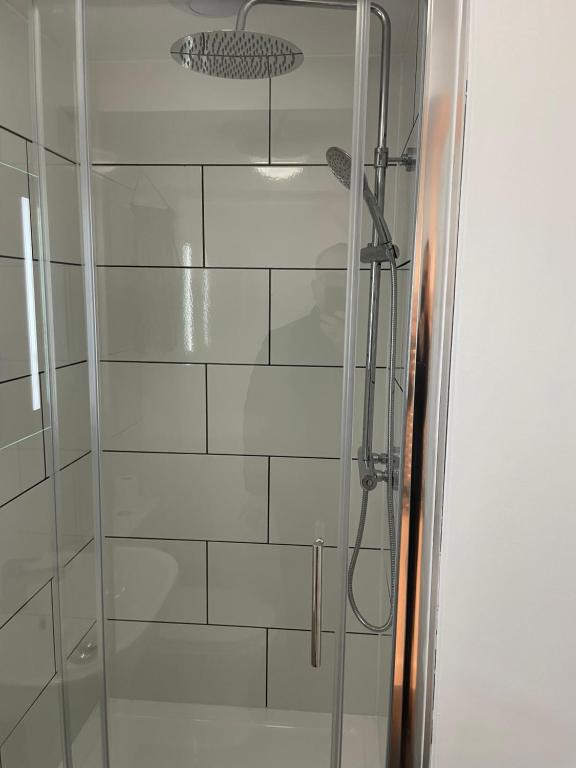 a shower with a glass door in a bathroom at Luxury Town Center Studio Stevenage in Stevenage