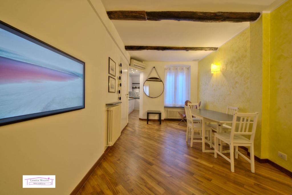 a living room with a table and a tv on a wall at Casetta Mazzini in Rapallo