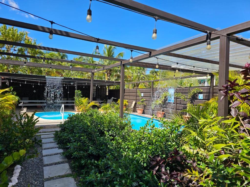 a pergola over a swimming pool with a fountain at Discovery Beach Apartments in Aguada