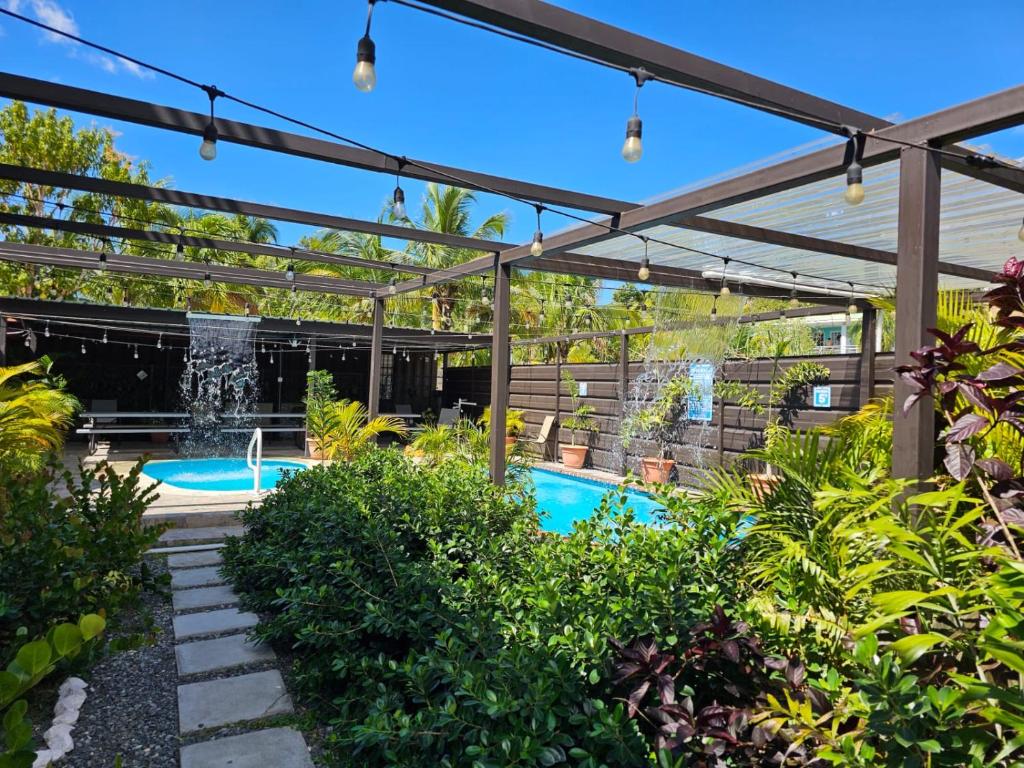 una pérgola sobre una piscina con una fuente en Discovery Beach Apartments, en Aguada