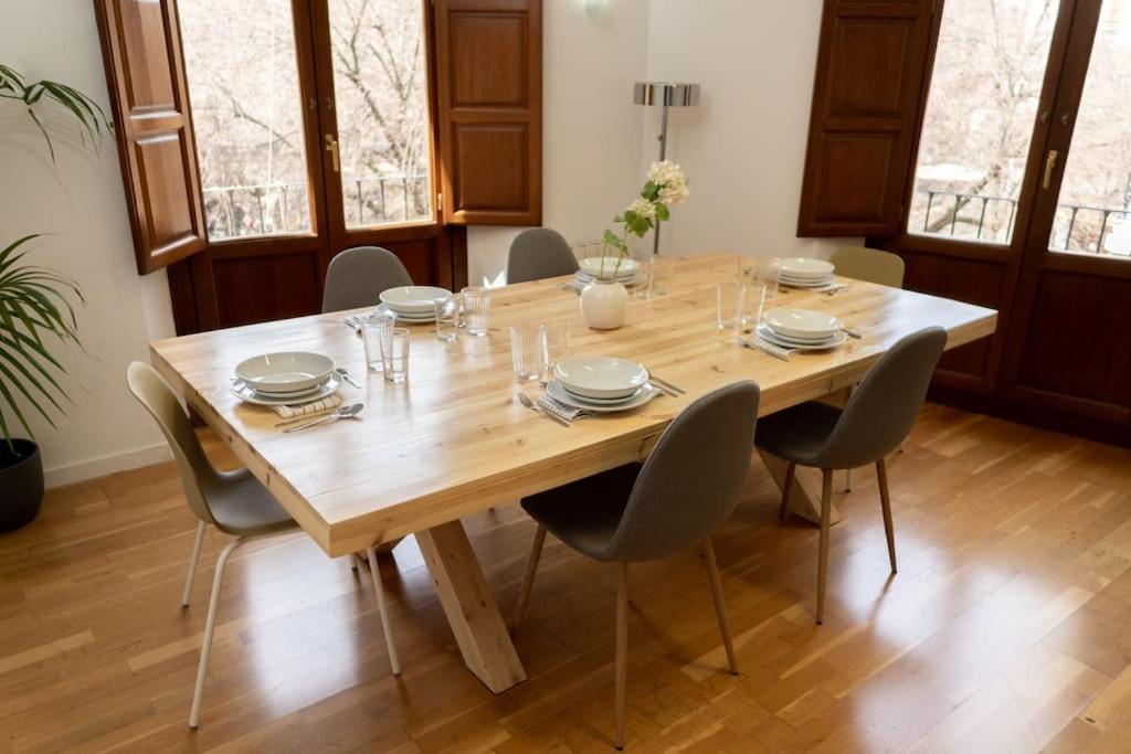 グラナダにあるSuite Alhambra Puerta Bib-Ramblaの椅子付きの部屋の木製テーブル