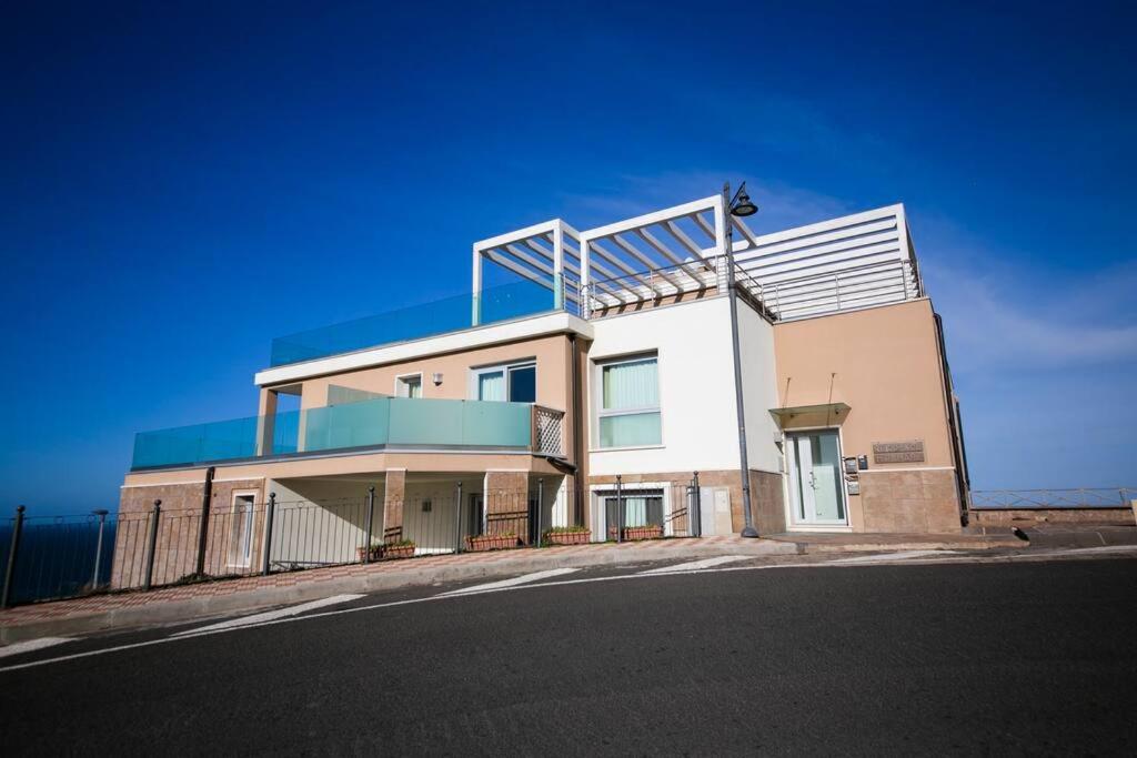 a large white building on the side of a street at Miramare_5 appartamento in Castelsardo