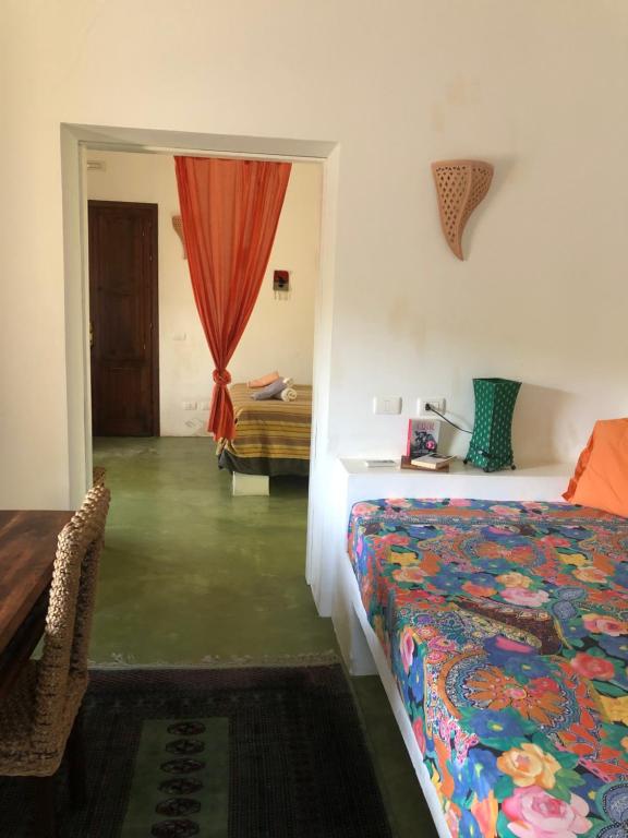 1 dormitorio con cama, mesa y ventana en Madilì, en Pantelleria