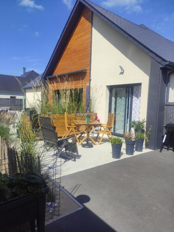 a patio of a house with a bench and plants at Studio les jardins de la brèche in Hermanville-sur-Mer