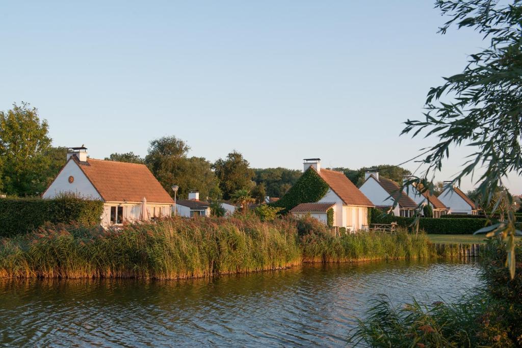 una fila di case vicino a un corpo d'acqua di Sunparks Oostduinkerke - Plopsaland a Oostduinkerke