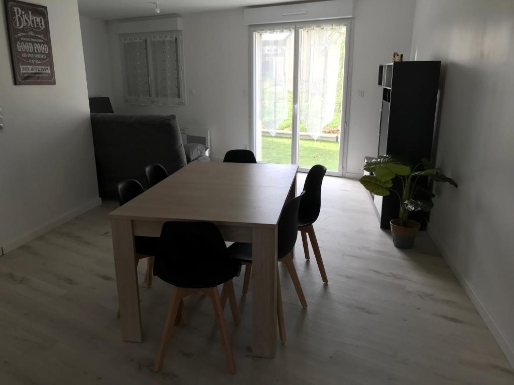 un comedor con mesa y sillas en una habitación en Appartement numéro 4 ou numéro 8 en Savigné-lʼÉvêque