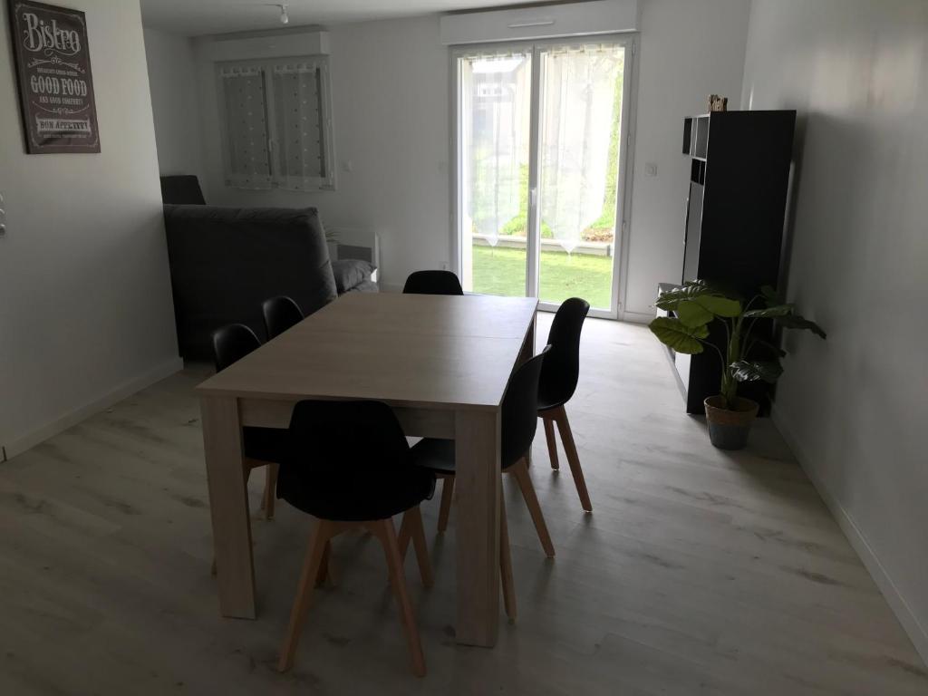 ein Esszimmer mit einem Tisch und Stühlen in einem Zimmer in der Unterkunft Appartement numéro 4 ou numéro 8 in Savigné-lʼÉvêque
