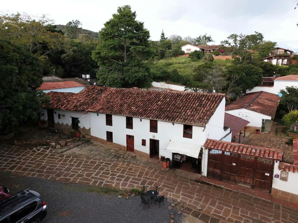 une vue aérienne sur un bâtiment blanc avec des toits rouges dans l'établissement Hostal Casa Ceiba, à Barichara