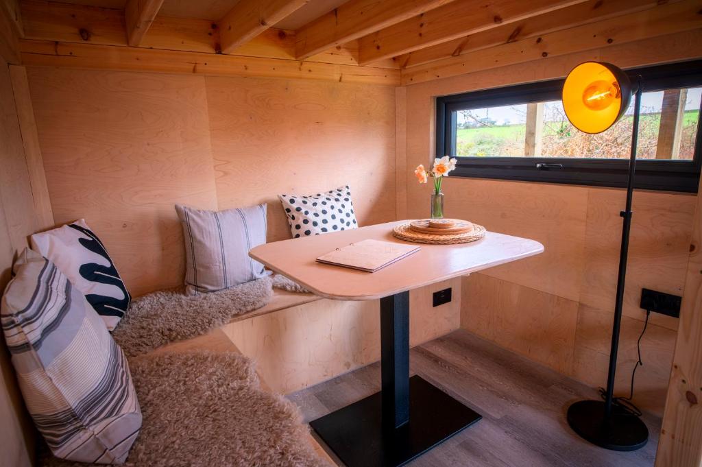 a tiny house with a table and a couch at Luxury Glamping Cabin with Outdoor Bath on Cornish Flower Farm in Truro