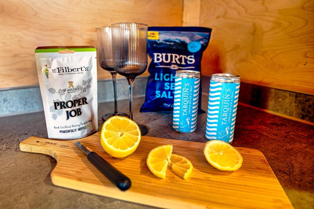 a cutting board with a blender and some orange slices at Luxury Glamping Cabin with Outdoor Bath on Cornish Flower Farm in Truro