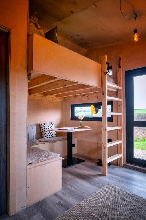 a room with a bunk bed and a table at Luxury Glamping Cabin with Outdoor Bath on Cornish Flower Farm in Truro