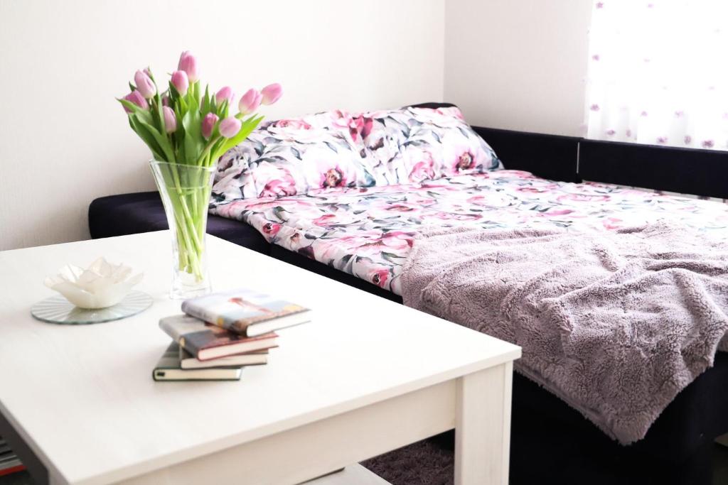 - une table basse avec un vase de fleurs dans l'établissement Magnolia apartment, à Liepāja