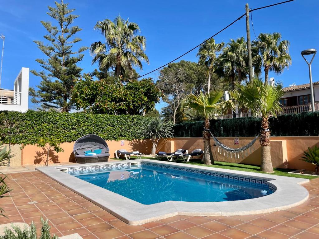 einen Pool in einem Garten mit Palmen in der Unterkunft Can Jaume Ferienhaus an der Playa de Palma mit Pool in Palma de Mallorca