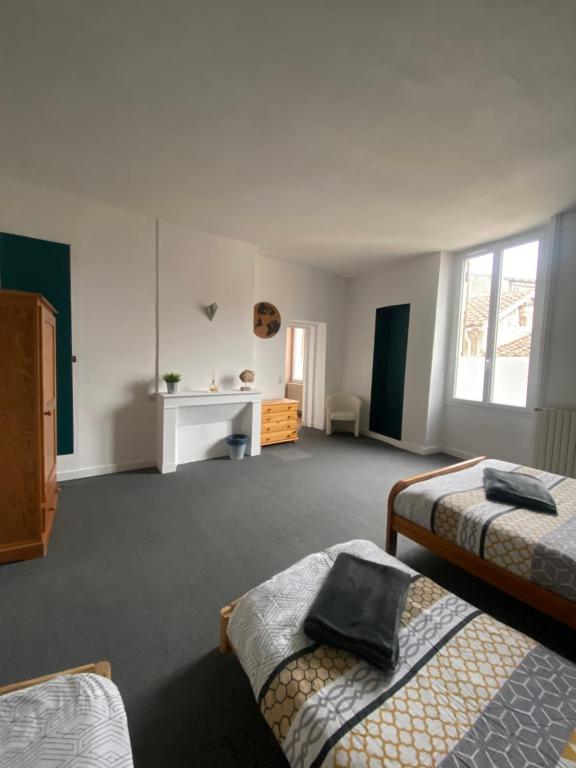 Habitación con 2 camas y escritorio. en Maison de casteljaloux 9 personnes, en Casteljaloux