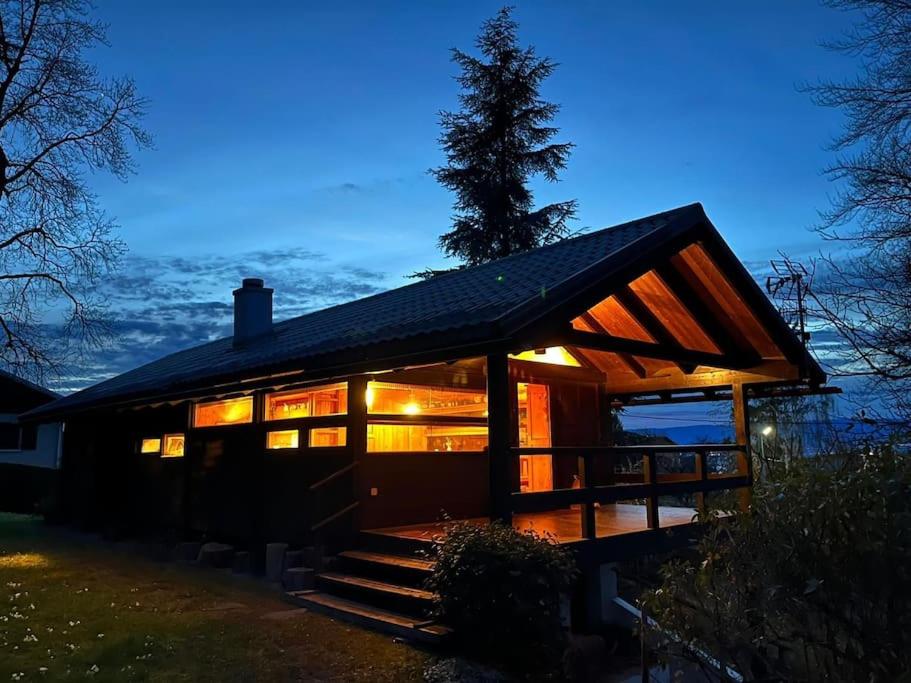 a cabin with lights on in the night at Le Fayard vue Lac in Publier