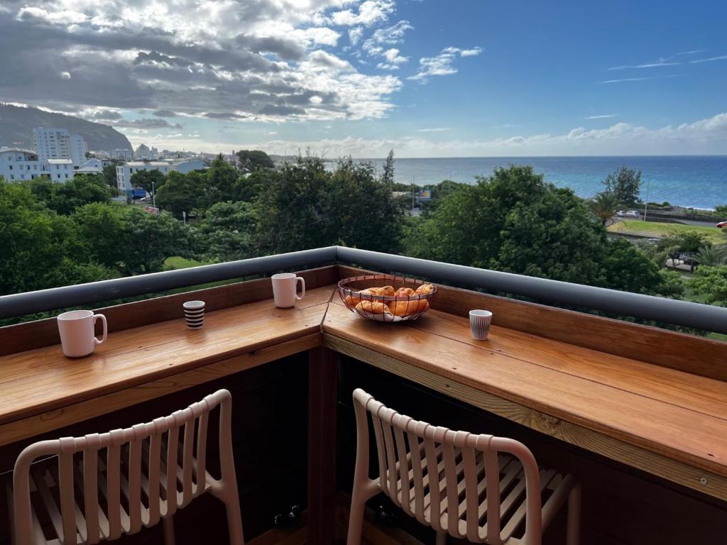 聖丹尼斯的住宿－Nouveauté Sunset appart vue exceptionelle，阳台配有两把椅子和一碗水果
