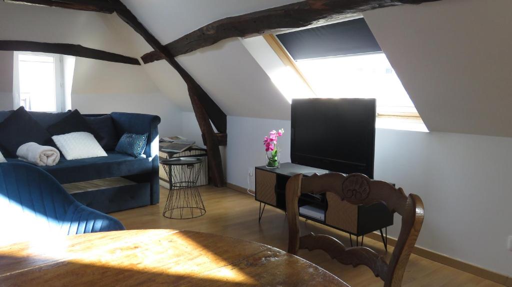 a living room with a blue couch and a tv at Chez Mary Poppins in Vernon