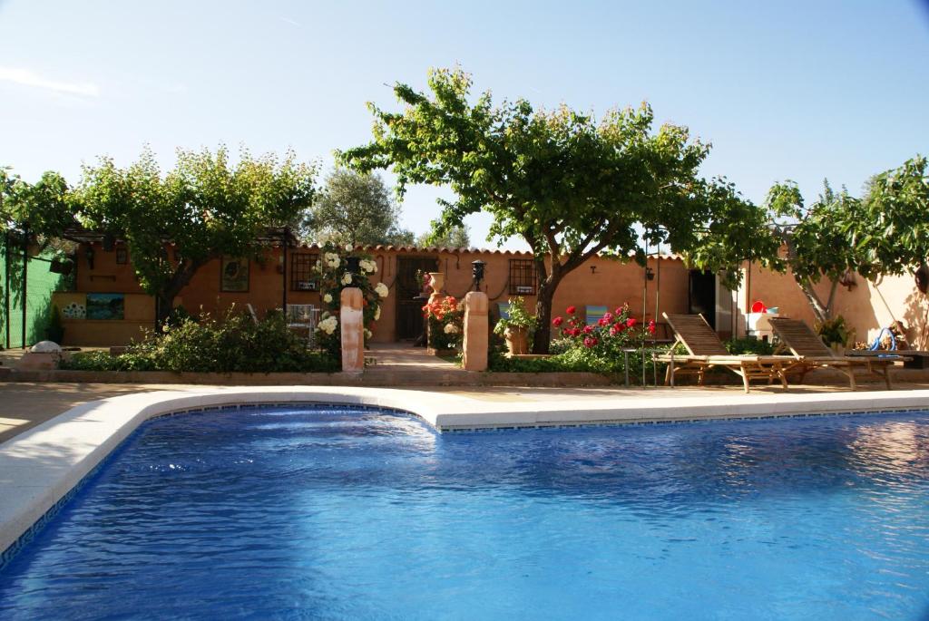 une grande piscine bleue en face d'une maison dans l'établissement Casa Rural Entre Volcanes de Almagro, à Almagro