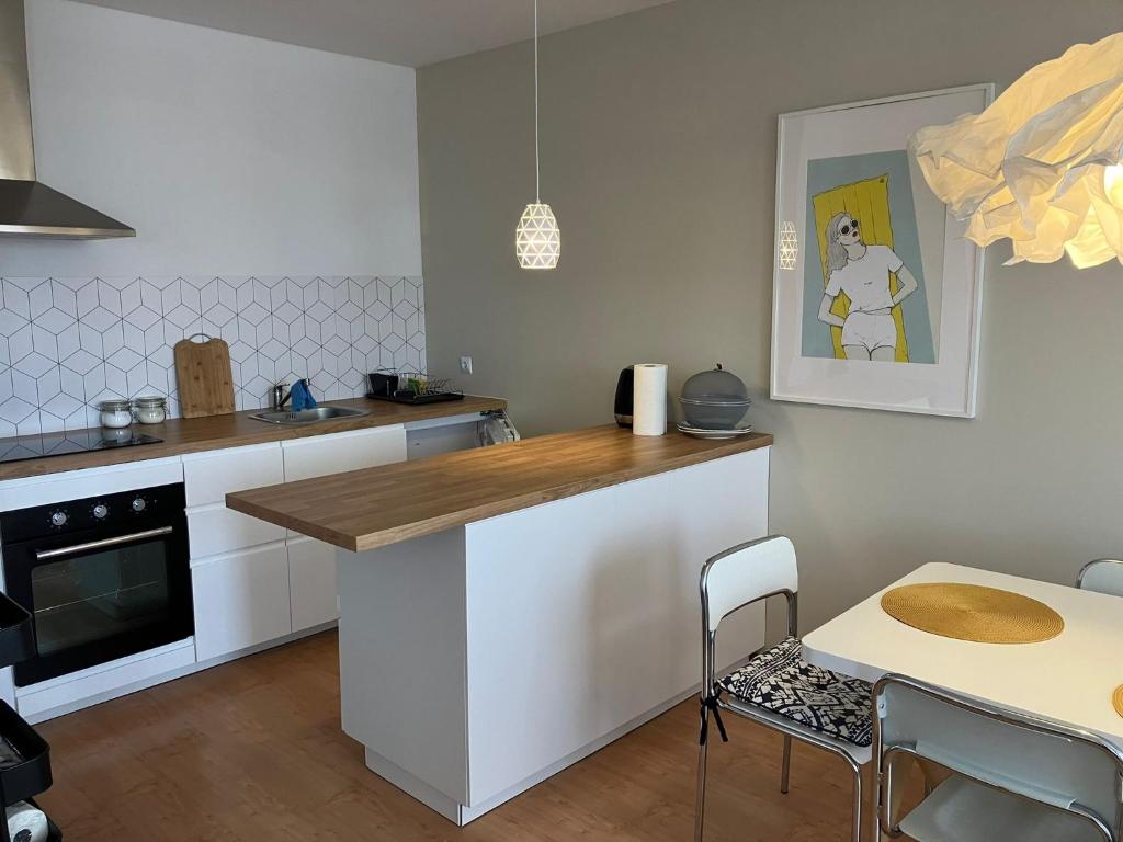 a kitchen with a counter and a table with chairs at Apartament Dziwnów in Dziwnów