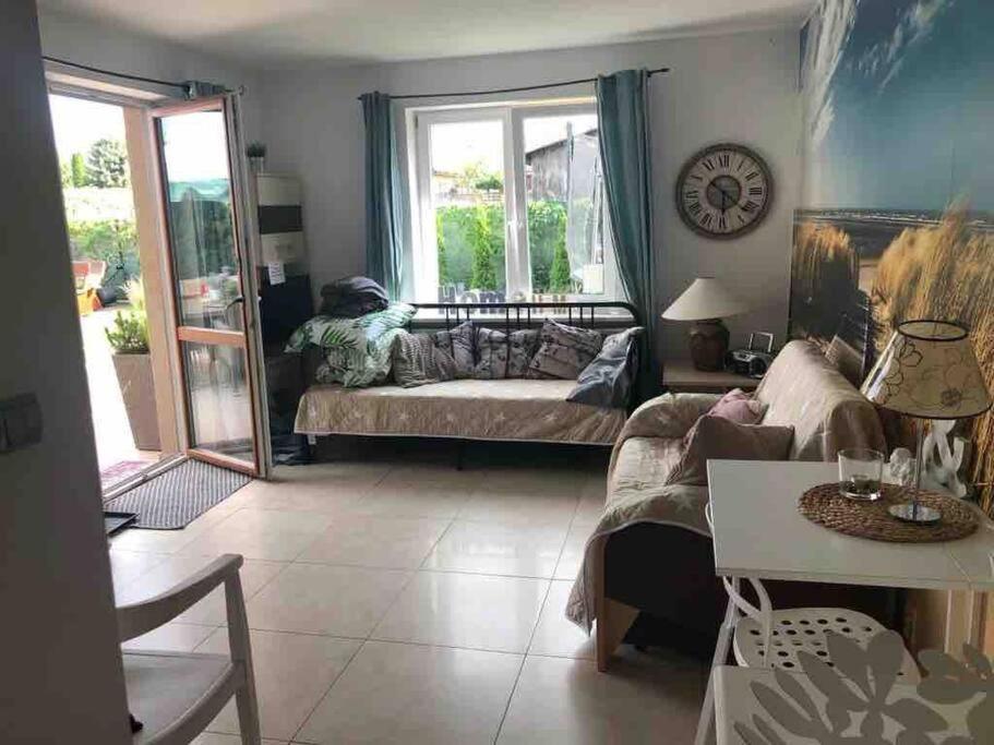 a living room with a couch and a table at Apartament Heniokite in Rewa
