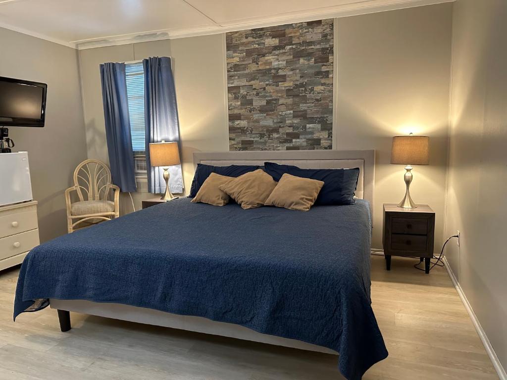 a bedroom with a large bed with a blue blanket at Blackbeard's Lodge in Ocracoke