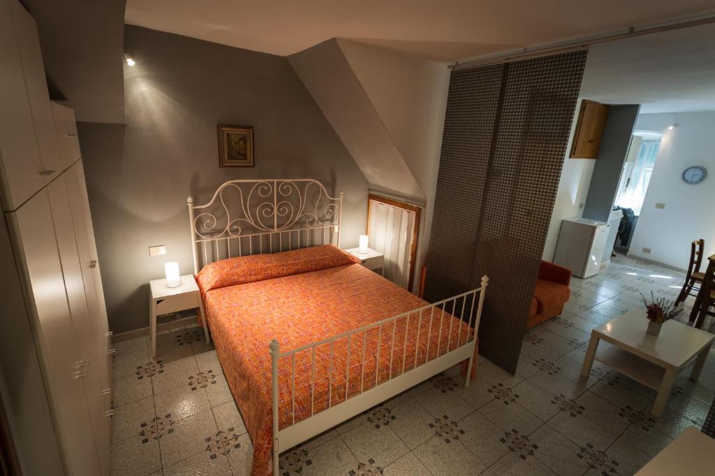 1 dormitorio con 1 cama con colcha de color naranja en Robs House, en Riomaggiore