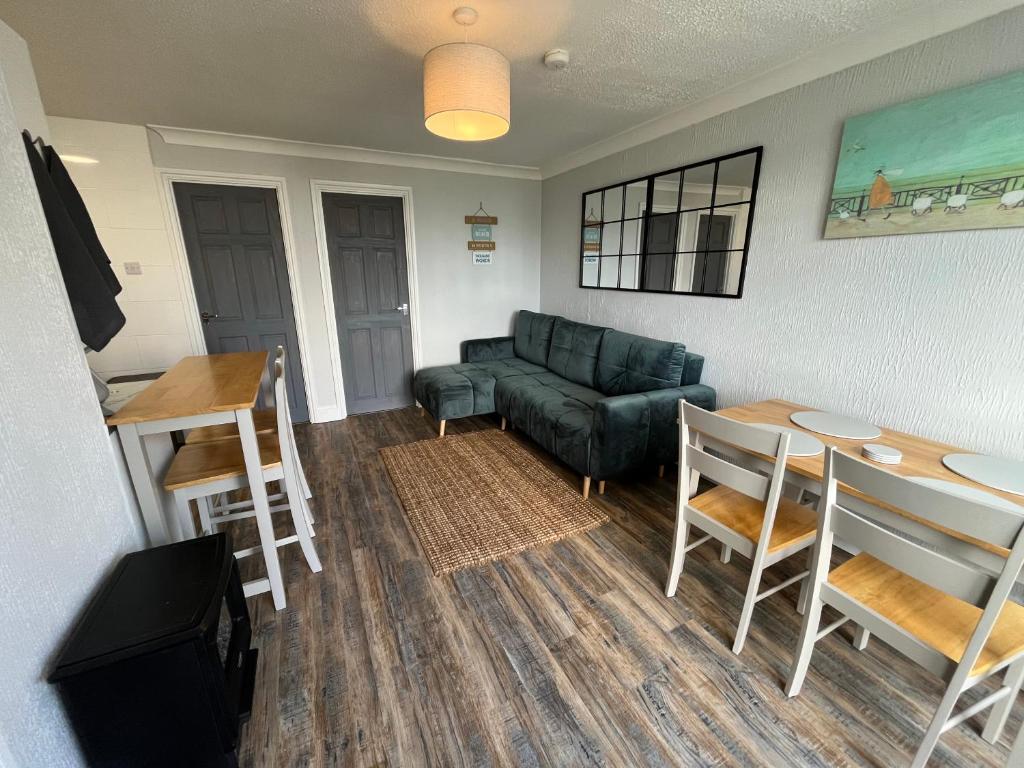 ein Wohnzimmer mit Sofa und Tisch in der Unterkunft 88, Belle Aire, Hemsby - Two bed chalet, sleeps 5, bed linen and towels included - pet friendly in Great Yarmouth