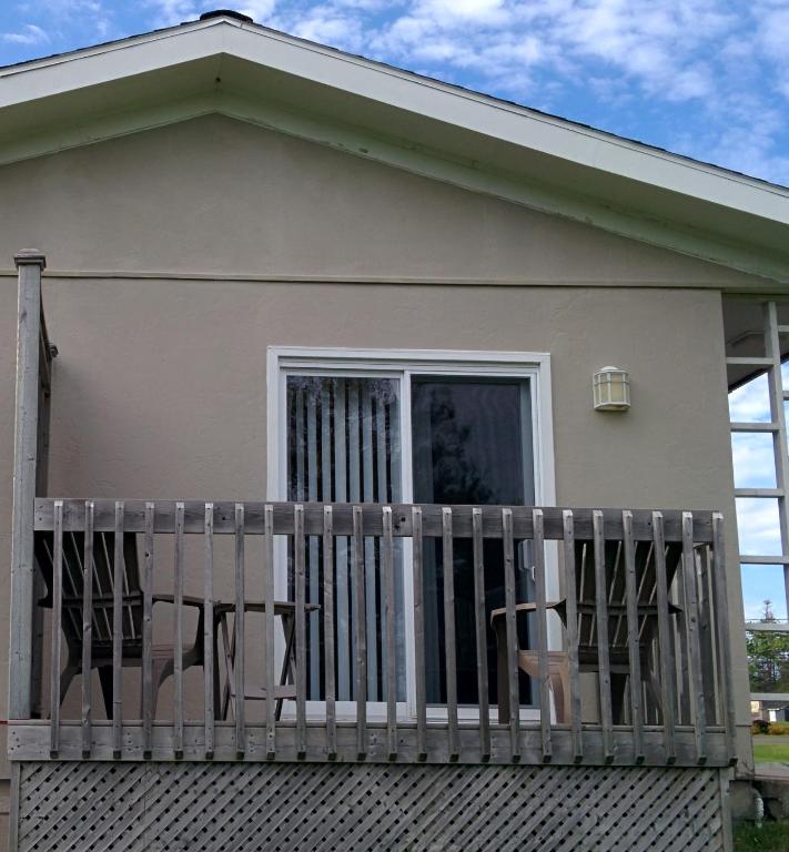 a house with a balcony with two chairs on it at Sunny Isle Motel in Summerside