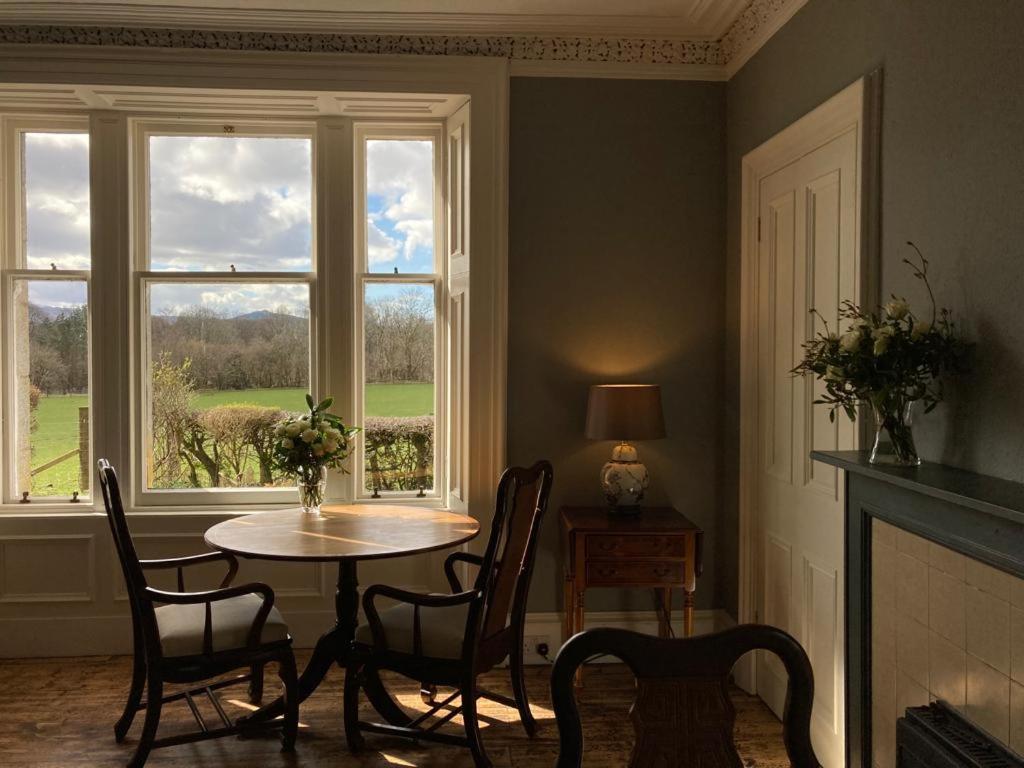 a dining room with a table and chairs and a window at Blarcreen in Oban