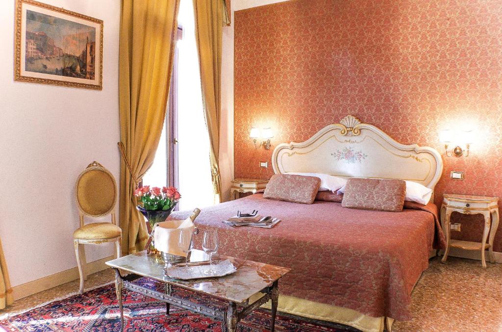 a hotel room with a bed and a table at Apostoli Palace in Venice