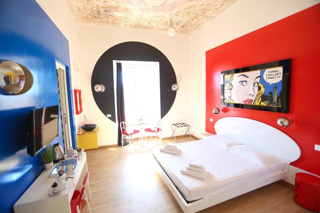a bedroom with a white bed and a red wall at KISS ME ROME Luxury Rooms in Rome
