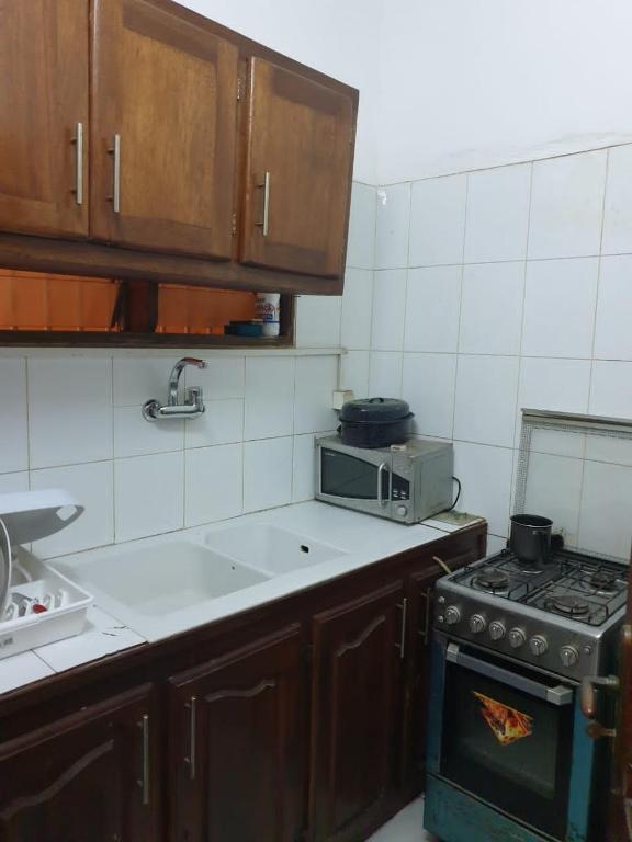 a kitchen with a stove and a microwave at Mousse Diop in Dakar