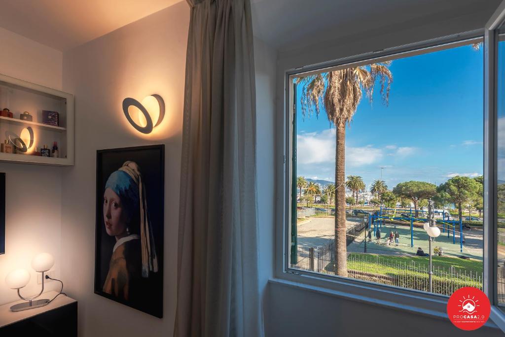a window with a view of a palm tree at Wild Zagara Garden View in La Spezia
