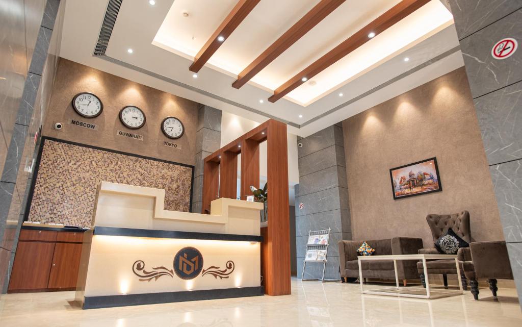 a lobby with two clocks on the wall at HOTEL BRAHMAPUTRA MADHUKALYA in Guwahati