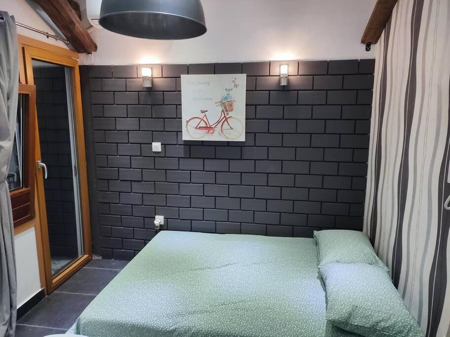 een bed in een kamer met een bakstenen muur bij Super Stylish Studio II in Thessaloniki