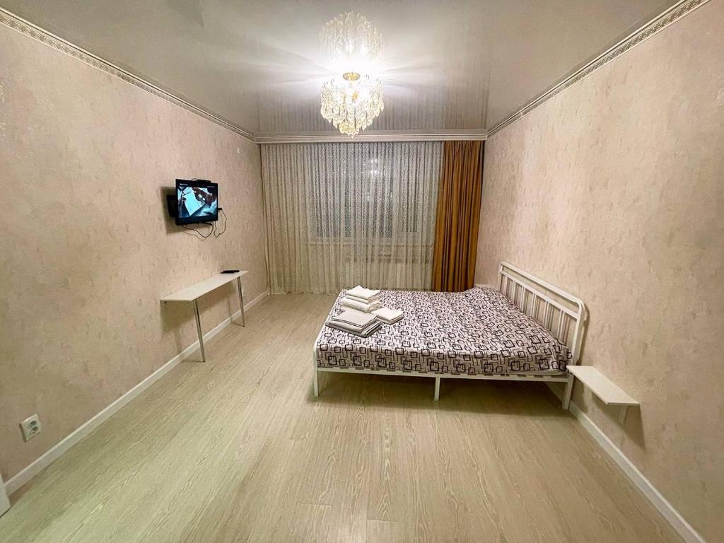 a room with a bed and a tv in it at Promenade Expo in Prigorodnyy