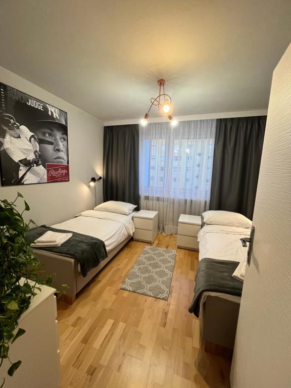 - une chambre avec 2 lits et un lustre dans l'établissement Mieszkanie nad Maltą, à Poznań