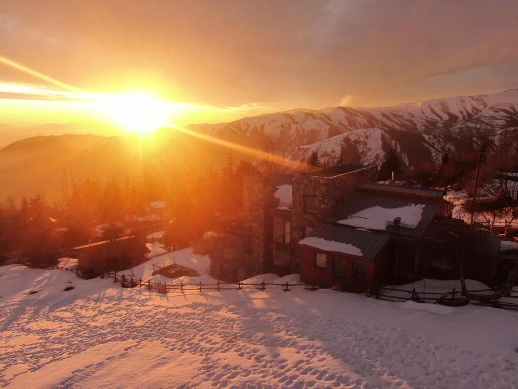 einen winterlichen Sonnenuntergang mit Sonnenuntergang über einem Berg in der Unterkunft Casa Farellones in Farellones