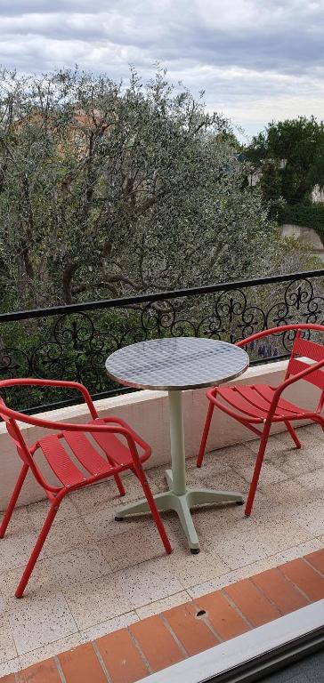 een tafel en 2 stoelen op een balkon bij 2 pièces calme et fonctionnel in Cagnes-sur-Mer