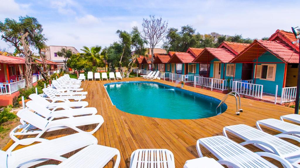 - une rangée de chaises et une piscine dans un complexe dans l'établissement Toll Garden, à Sidé