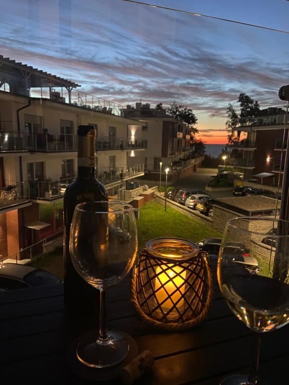 einen Tisch mit zwei Weingläsern und einer Flasche Wein in der Unterkunft Resort Apartamenty Klifowa Rewal 55 in Rewal