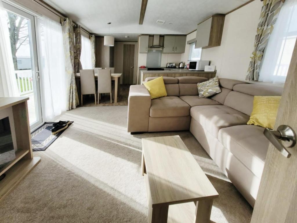 ein Wohnzimmer mit einem Sofa und einem Tisch in der Unterkunft Nightingale in South Cerney