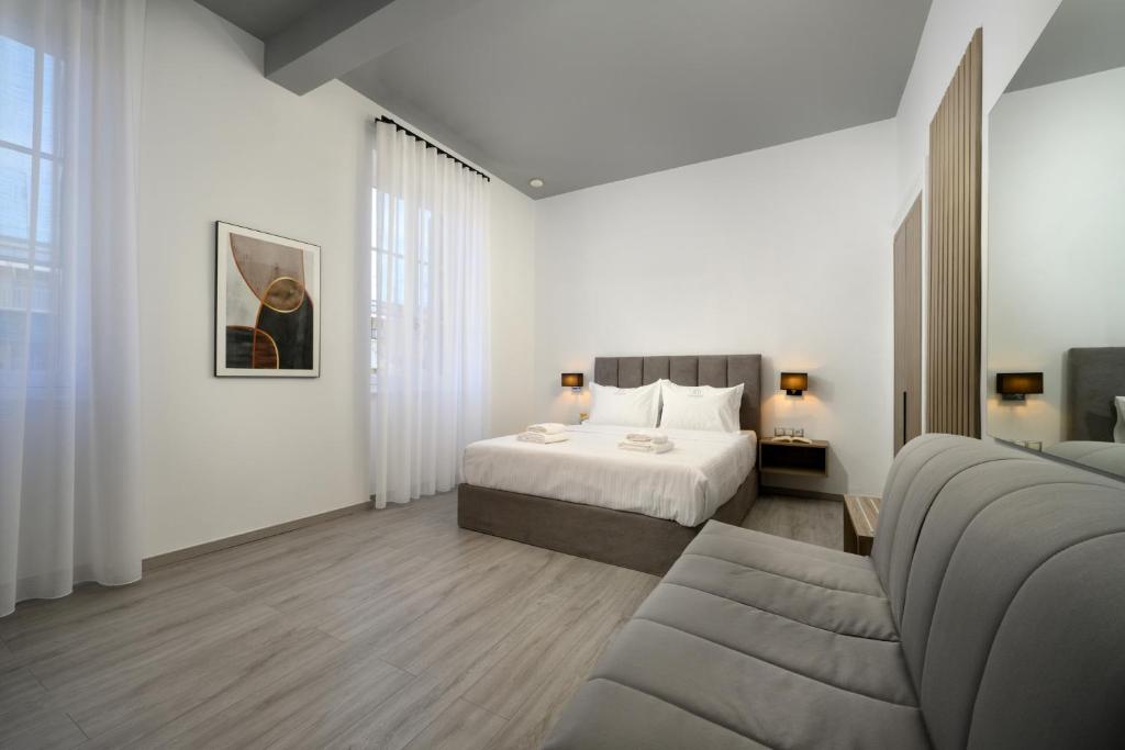 ein Hotelzimmer mit einem Bett und einem Sofa in der Unterkunft AMALPHI Corfu City Living in Korfu-Stadt
