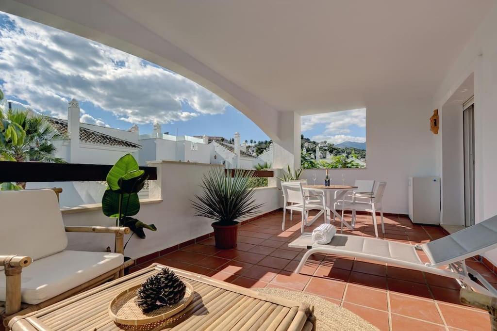 ein Wohnzimmer mit einem Balkon mit einem Tisch und Stühlen in der Unterkunft Stylish apartment in Aloha Royal in Marbella