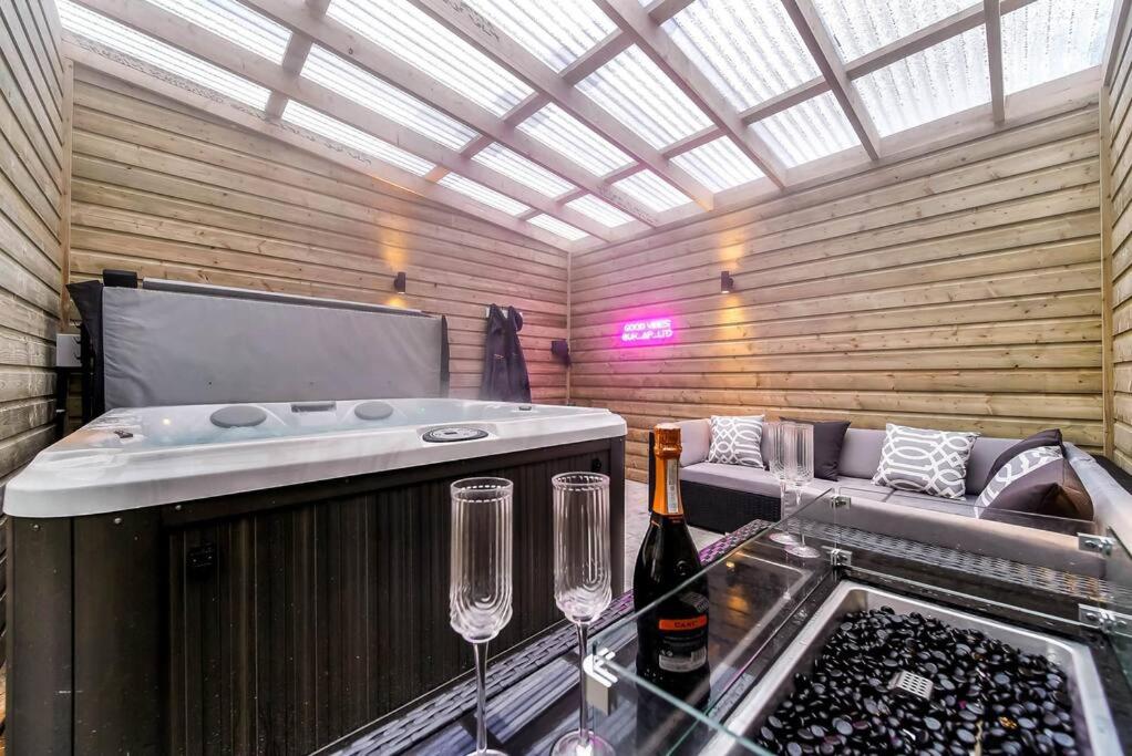 um quarto com dois copos de vinho e uma banheira de hidromassagem em Ardoyne Lodge 'Sleeping 4 Guests' em Belfast