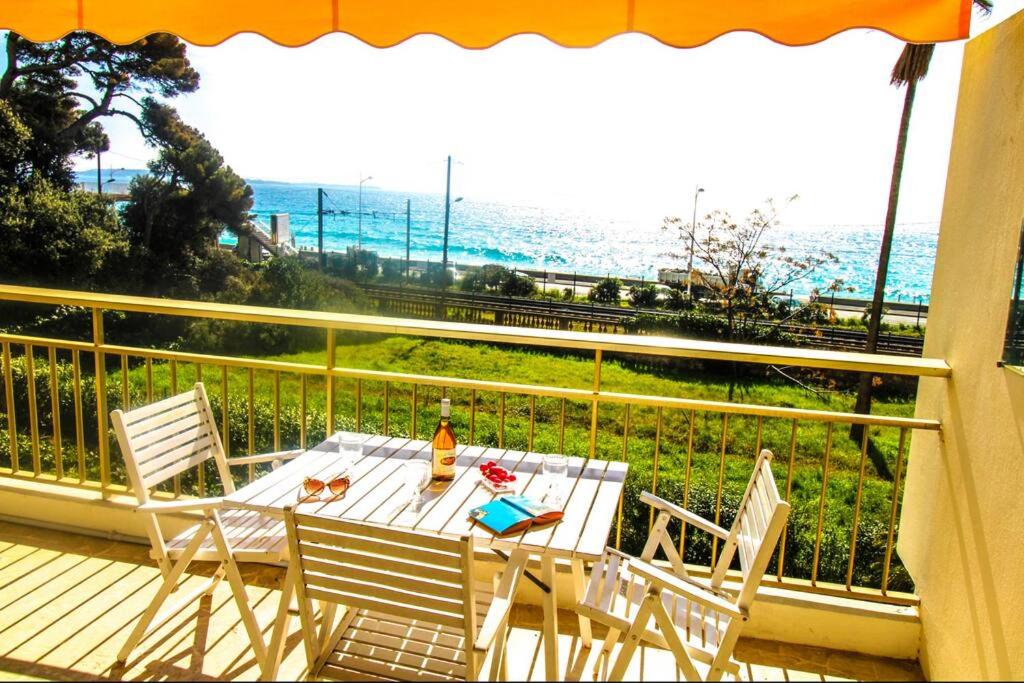 a table and chairs on a balcony with a view of the ocean at Le Trident YourHostHelper in Cannes