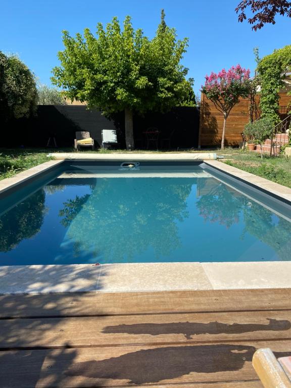 una piscina de agua azul en un patio en Gîte Lou Sabaï au pied des dentelles de Montmirail, piscine partagée, en Aubignan