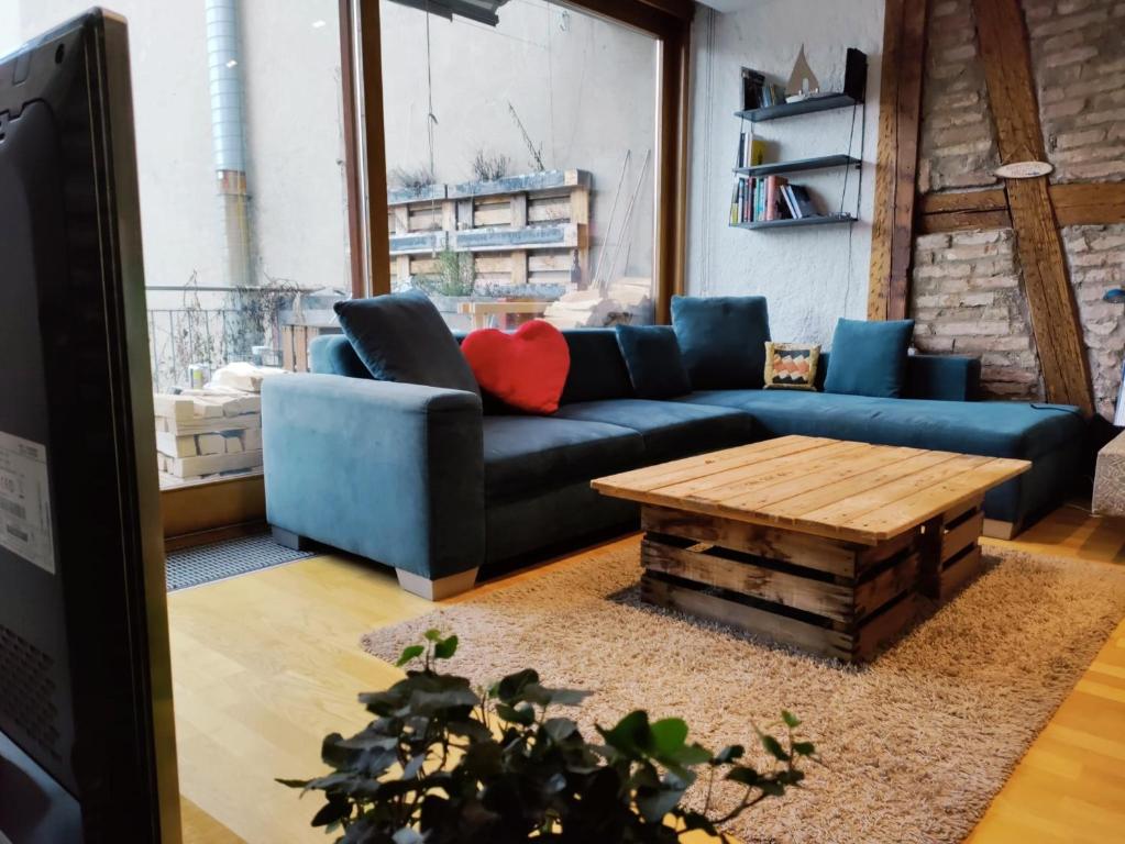 a living room with a blue couch and a wooden table at Central-city Penthouse in Bern