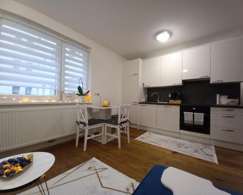 維也納的住宿－Lauro Apartment，厨房配有白色橱柜、桌子和窗户。
