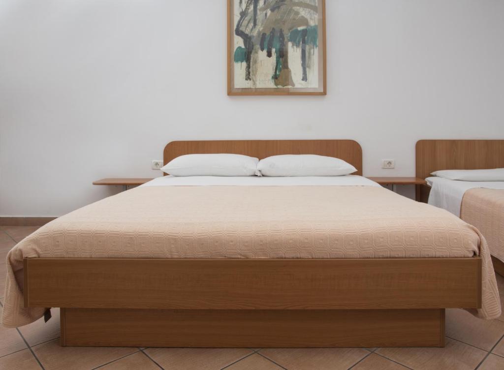 1 dormitorio con 1 cama grande y cabecero de madera en Jazz Apartments, en Piran
